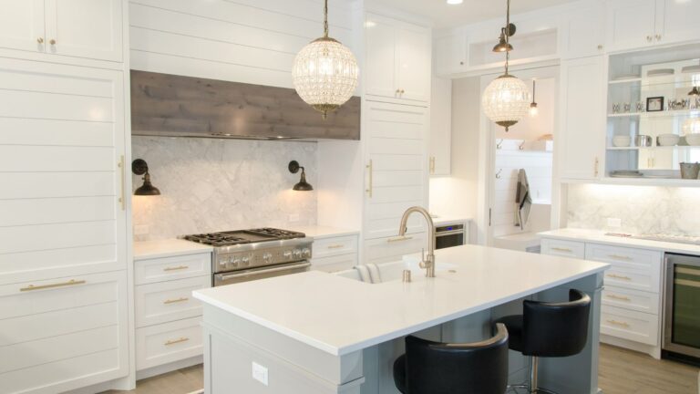 Remodeled white kitchen with a large island and pendant lights by United Home Builders in the Upper Cumberland